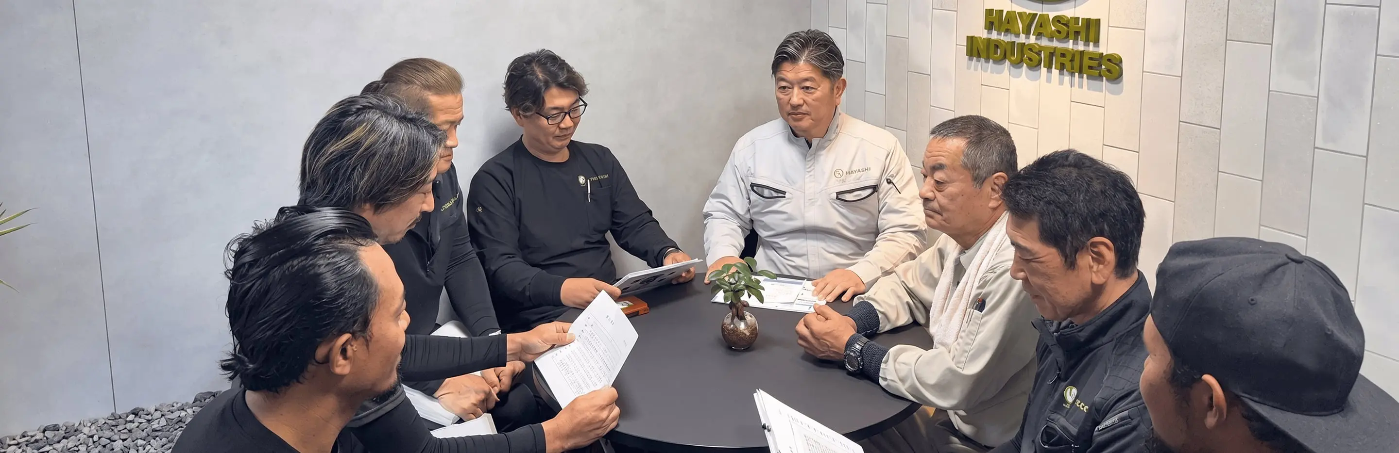 会議室で図面を囲んで打ち合わせをする林工業株式会社の作業員たち