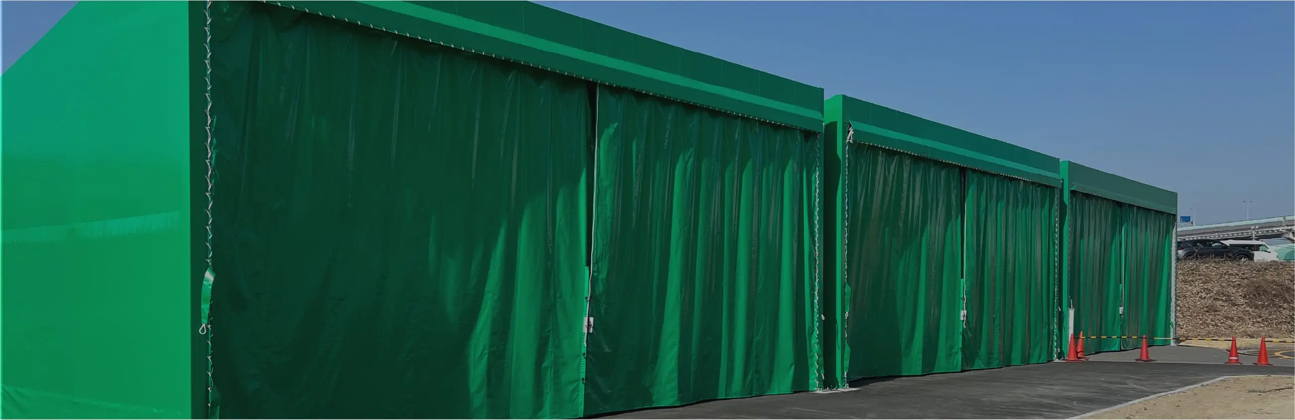 緑色の仮囲いで覆われた建築工事現場の外観